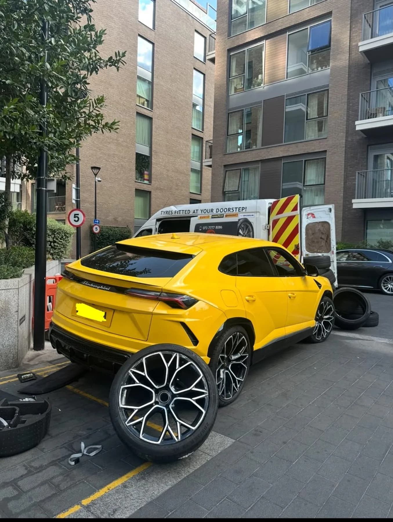 Yellow SUV on a street with alloy wheels removed during a fitting